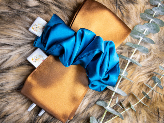 Heatless Curl Silk Hair Tie- Brilliant Blue & Bronze. Bronze silk tie with jewel blue scrunchie laying on fur.