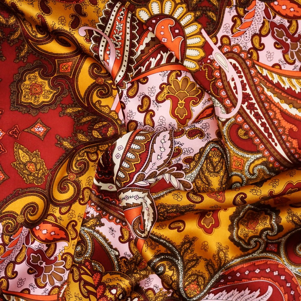 Close up of red, gold, brown, pink paisley silk fabric