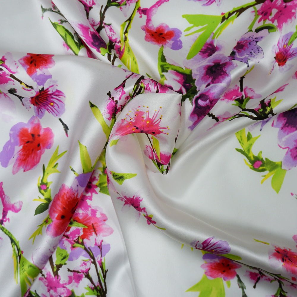 Close up of scrunchie fabric. White silk fabric with pink, green, purple water colour blooms and brown stems.