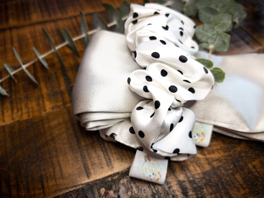 Heatless Curl Silk Hair Tie- Silver & Spots. Silver silk tie with white and black dotted scrunchie around it on wood table.